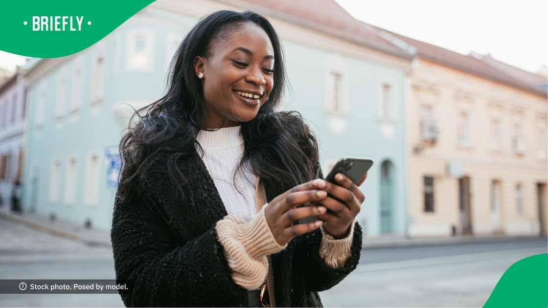 A woman smiling at her phone.