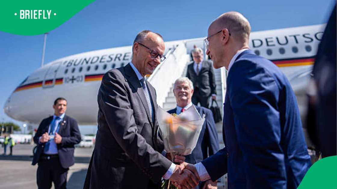German Chancellor Friedrich Merz is welcomed by Ambassador Andreas Peschke