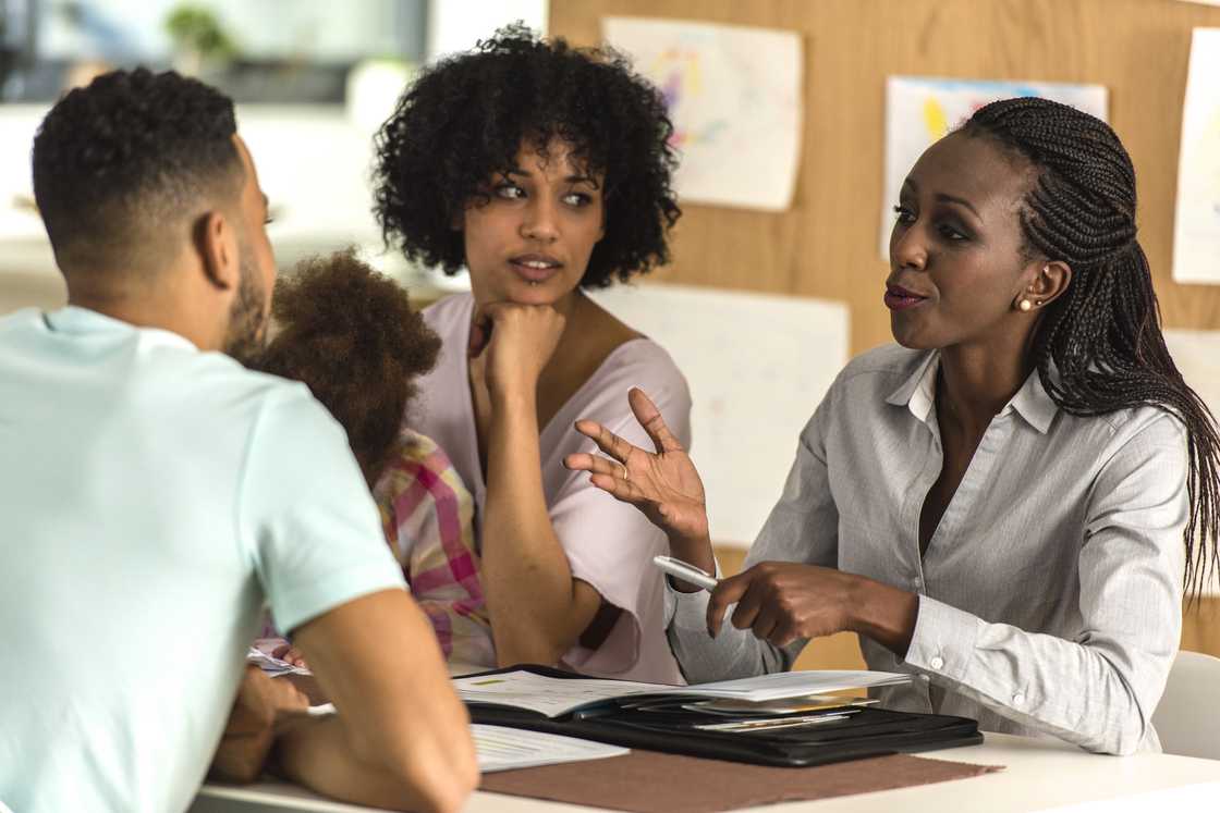 Headteacher, teacher, and parent in discussion inside an office. Headteacher, teacher, and parent in discussion inside an office.