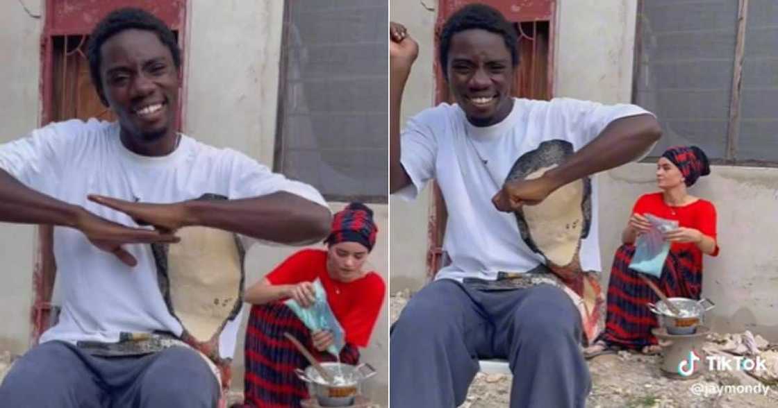 Man shows girlfriend cooking African food over fire Man shows girlfriend cooking African food over fire