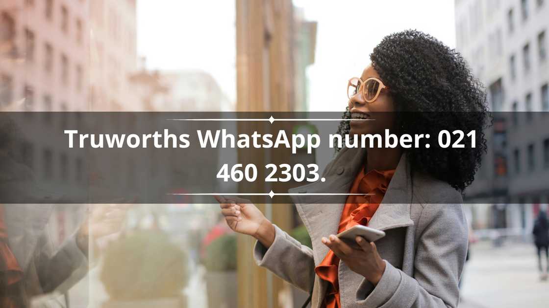 A woman standing outside a store holding her phone while smiling A woman standing outside a store holding her phone while smiling