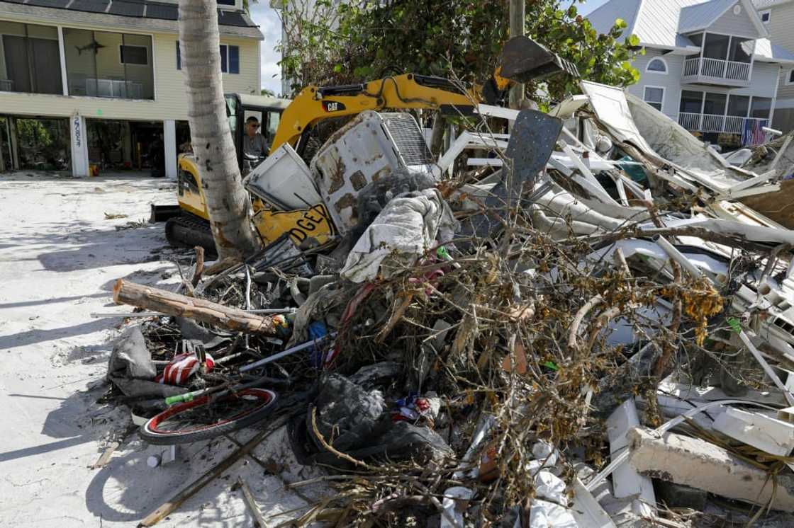 A laborer uses heavy machinery to remove rubble in Bonita Springs, Florida, on November 2, 2022 A laborer uses heavy machinery to remove rubble in Bonita Springs, Florida, on November 2, 2022