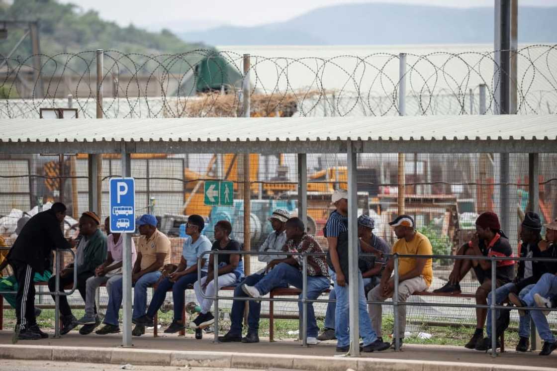 Workers wait at the surface for news of more than 2,000 miners occupying the Impala Bafokeng platinum mine since Monday