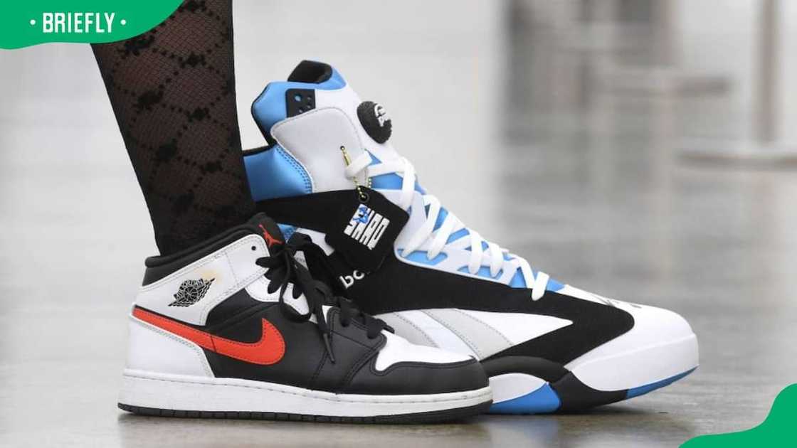 An assistant placing her sneaker next to a pair of signed Shaquille O'Neil's sneakers