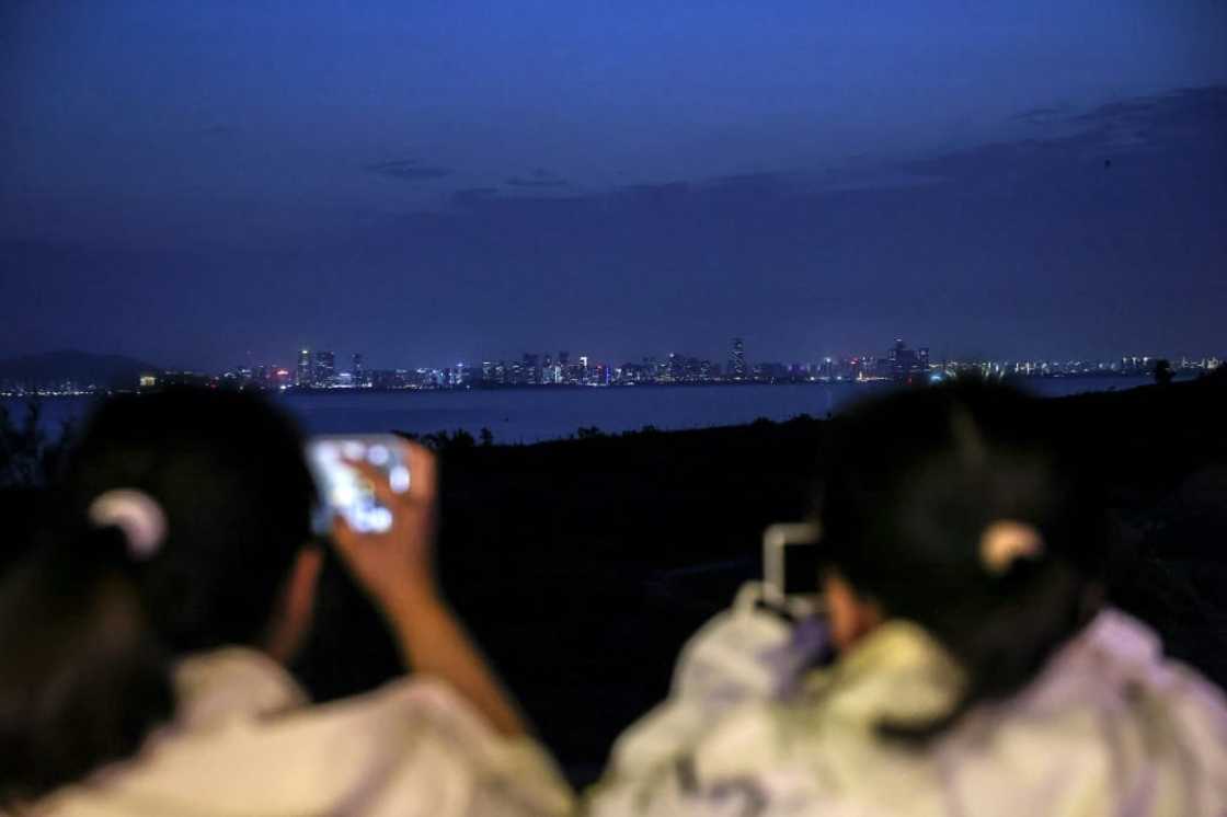 Visitors take pictures of the Chinese city of Xiamen from the Taiwan-controlled Kinmen islands Visitors take pictures of the Chinese city of Xiamen from the Taiwan-controlled Kinmen islands