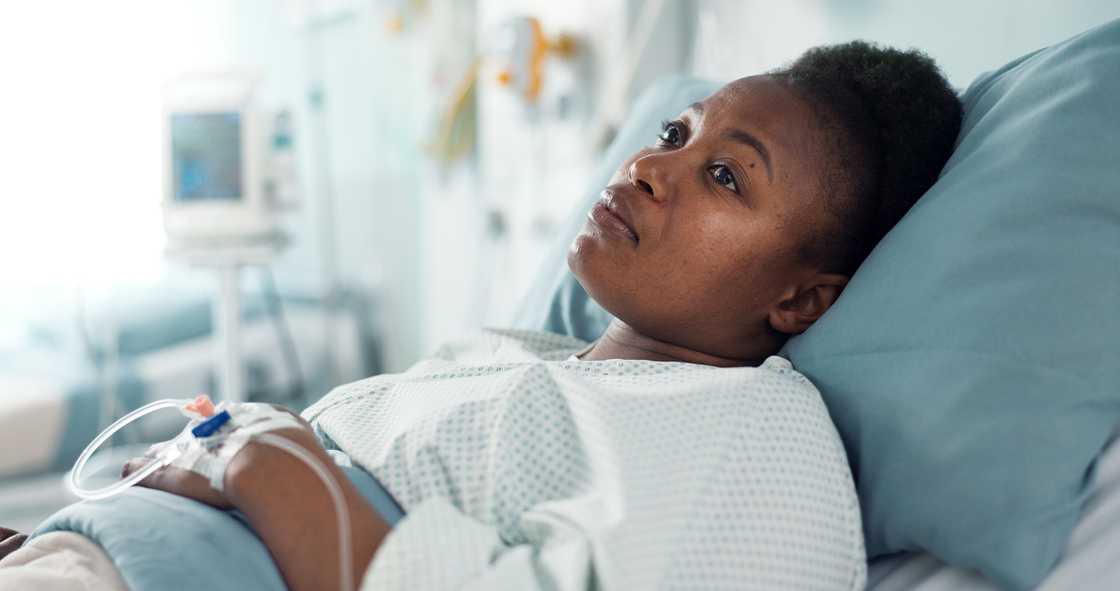 Sad, sick, and a thinking black woman in a hospital bed