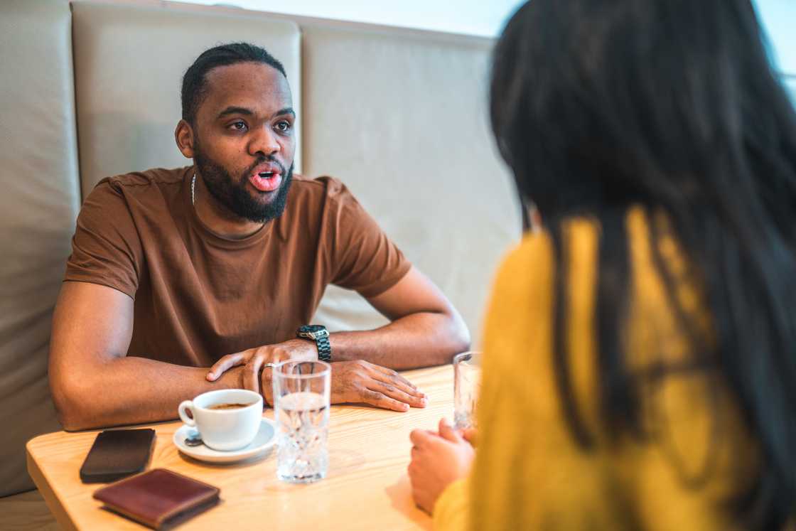 A couple talking while sitting at the dining table