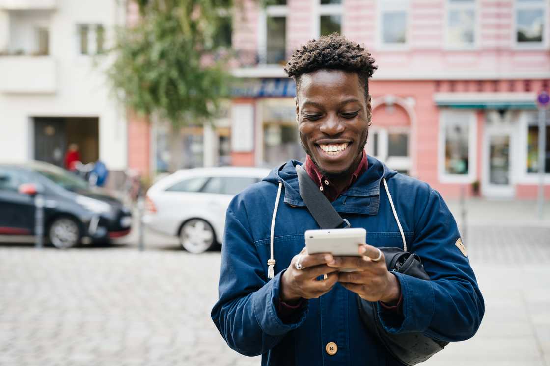 A man smiling at his smartphone.