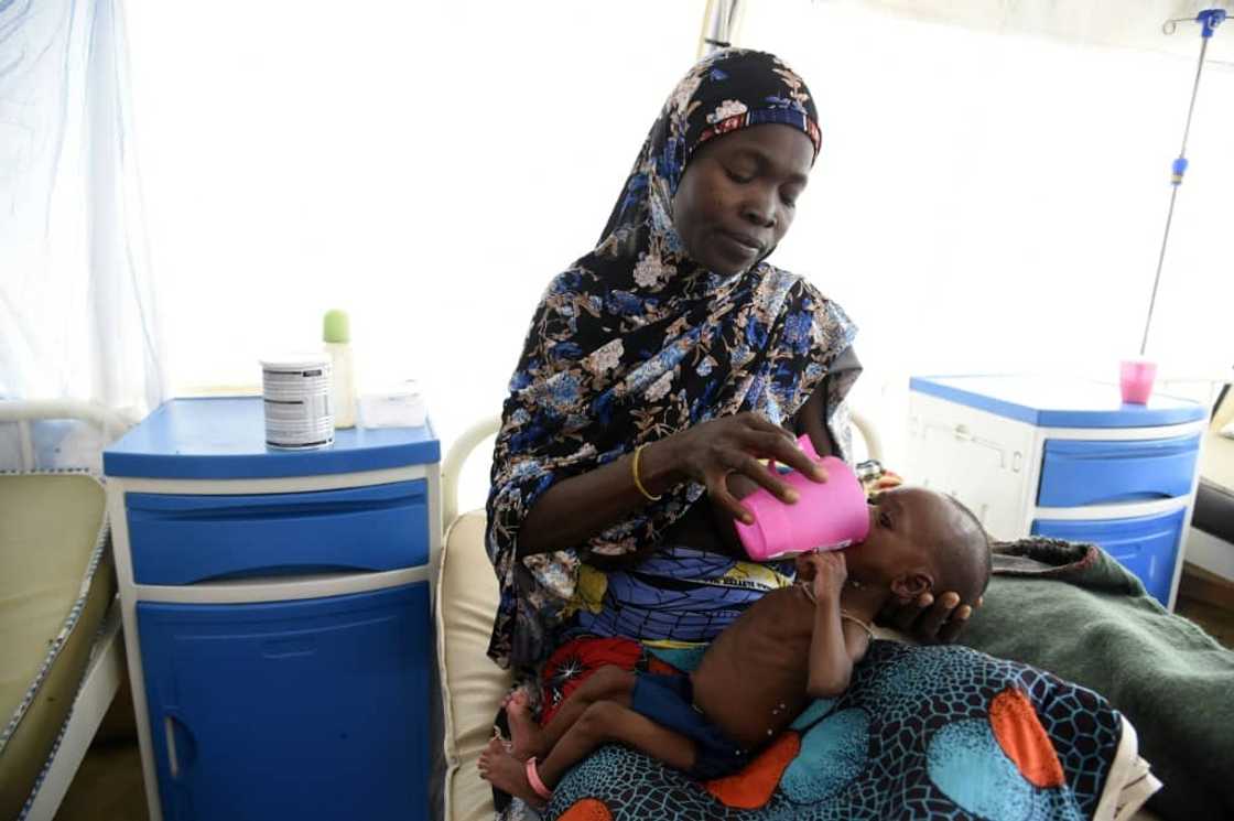 A woman at an MSF malnutrition clinic feeds the child of her late sister A woman at an MSF malnutrition clinic feeds the child of her late sister