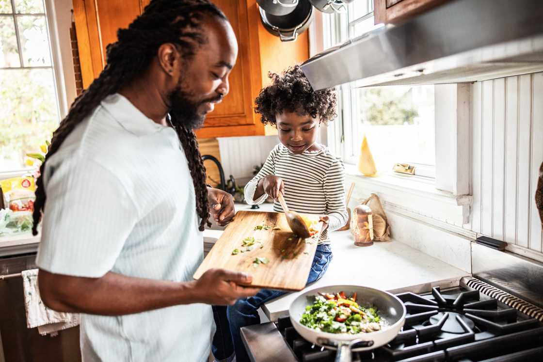 A stock image of father and daughter cooking