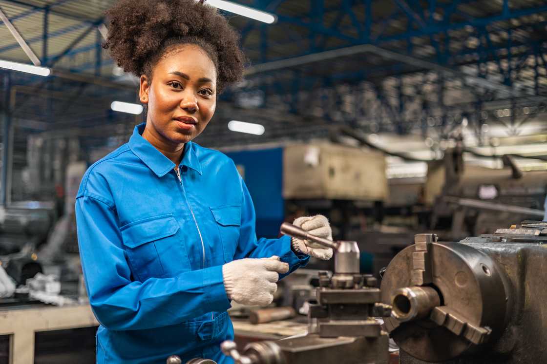 A young woman operating a machine at factory industrial. A young woman operating a machine at factory industrial.