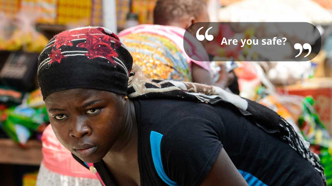 A saleswoman bending at the market while talking