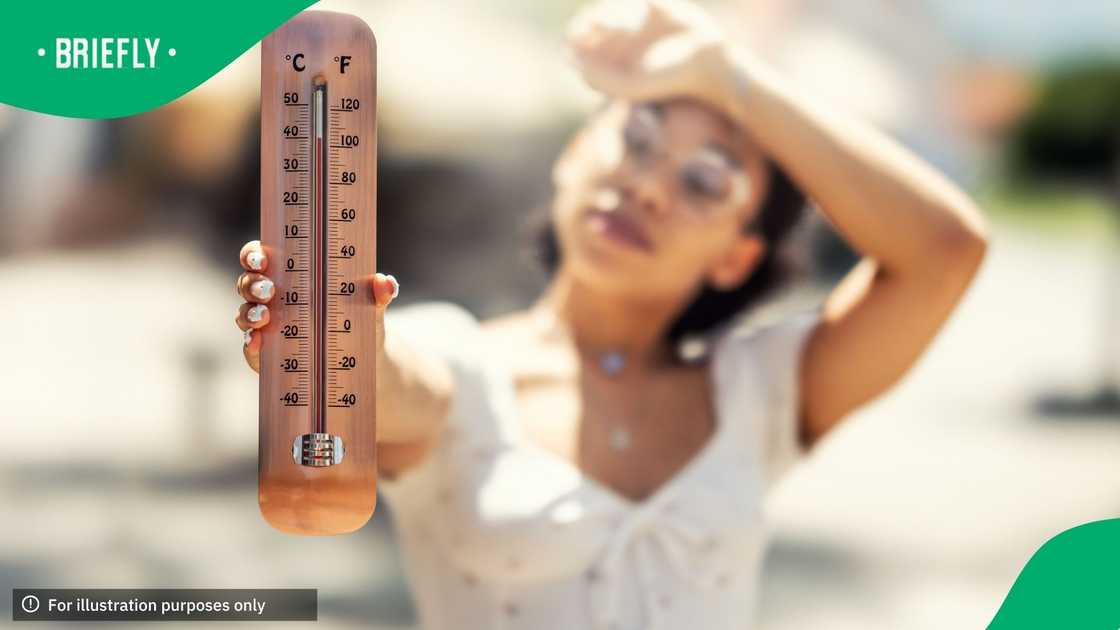 A thermometer showing high temperatures, held by a young woman who is very hot