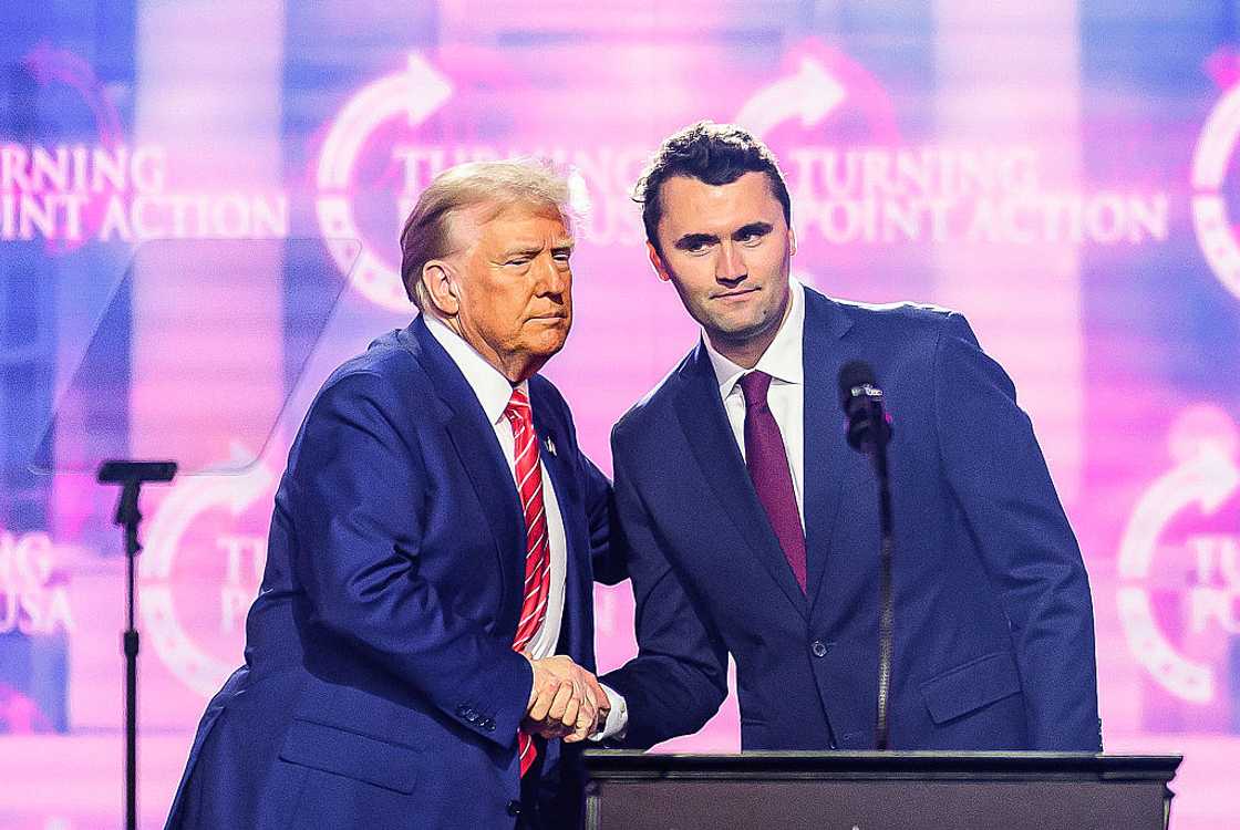 Charlie Kirk (R) shaking hands with US President Donald Trump