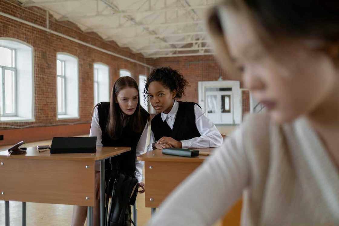 students whispering in a classroom