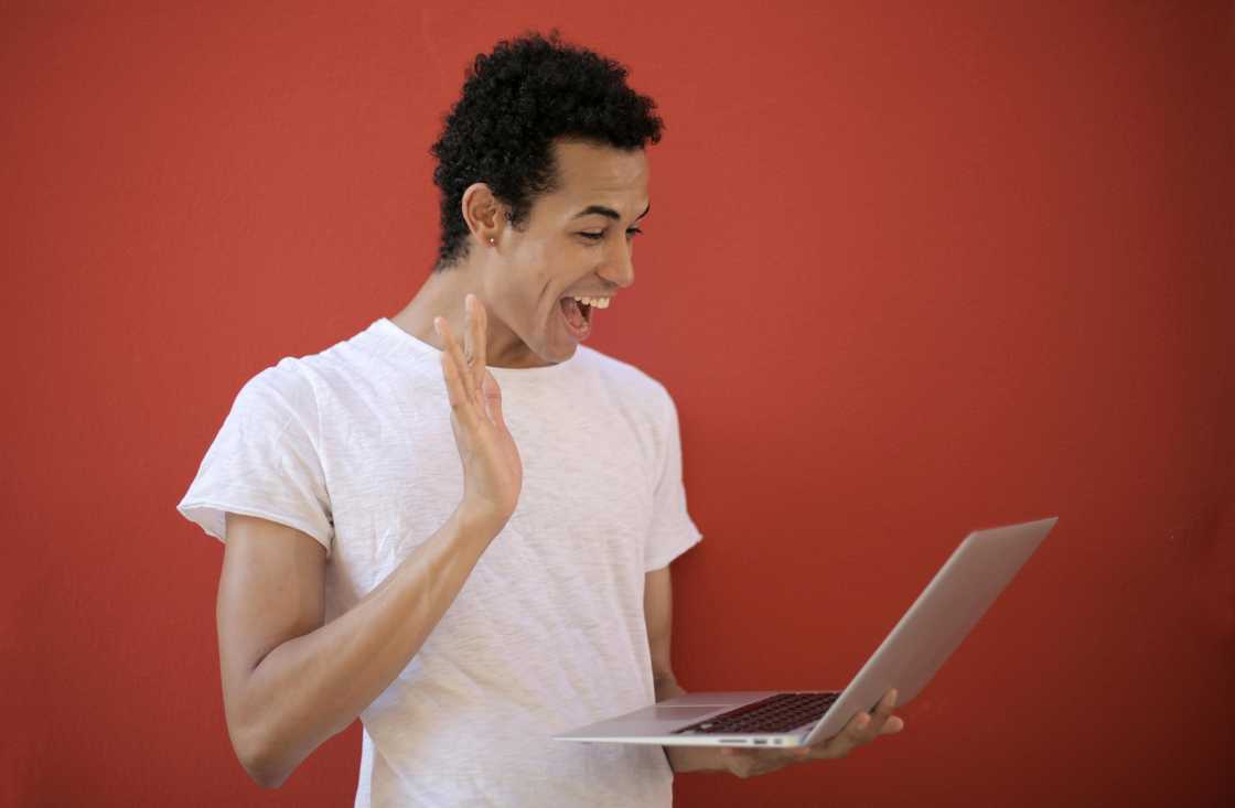 Cheerful man using laptop.