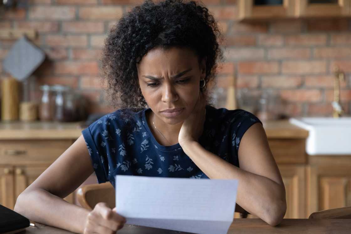 An unhappy woman reading a letter. An unhappy woman reading a letter.