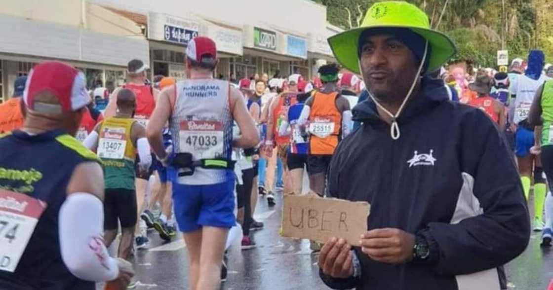 Man holding Uber sign at The Comrades Marathon Man holding Uber sign at The Comrades Marathon