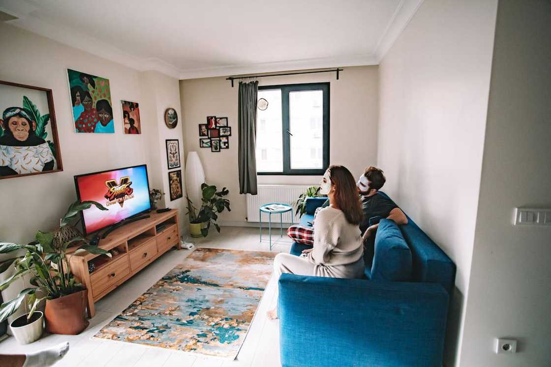 A couple sitting on a sofa watching television