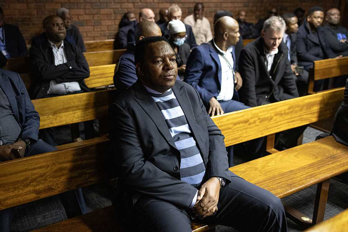 Suspended South African National Police Commissioner General Fannie Masemola (C) sits as he appears for charges linked to an irregular Medicare24 police tender, at the Pretoria Magistrate's Court in Pretoria on May 13, 2026
