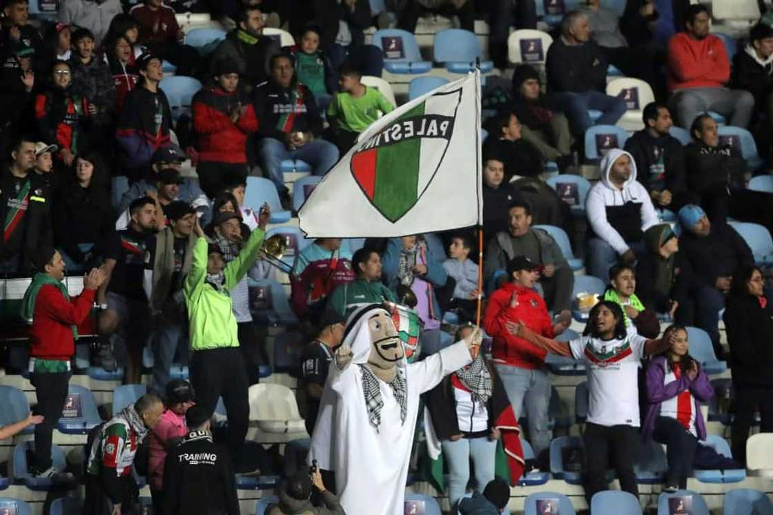 Francisco Muñoz (C), a 48-year-old janitor, cheers for his team Palestino wearing an Arab sheikh costume during the Copa Sudamericana match against Estudiantes de Merida in Rancagua, Chile, on April 18, 2023 Francisco Muñoz (C), a 48-year-old janitor, cheers for his team Palestino wearing an Arab sheikh costume during the Copa Sudamericana match against Estudiantes de Merida in Rancagua, Chile, on April 18, 2023