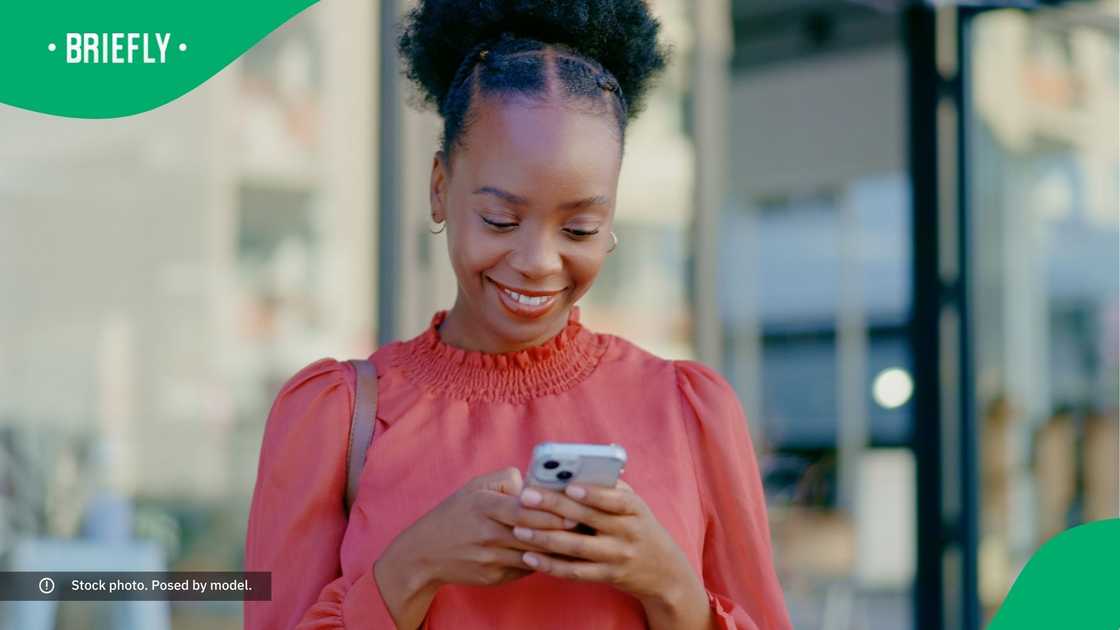 A woman smiling at her phone. A woman smiling at her phone.