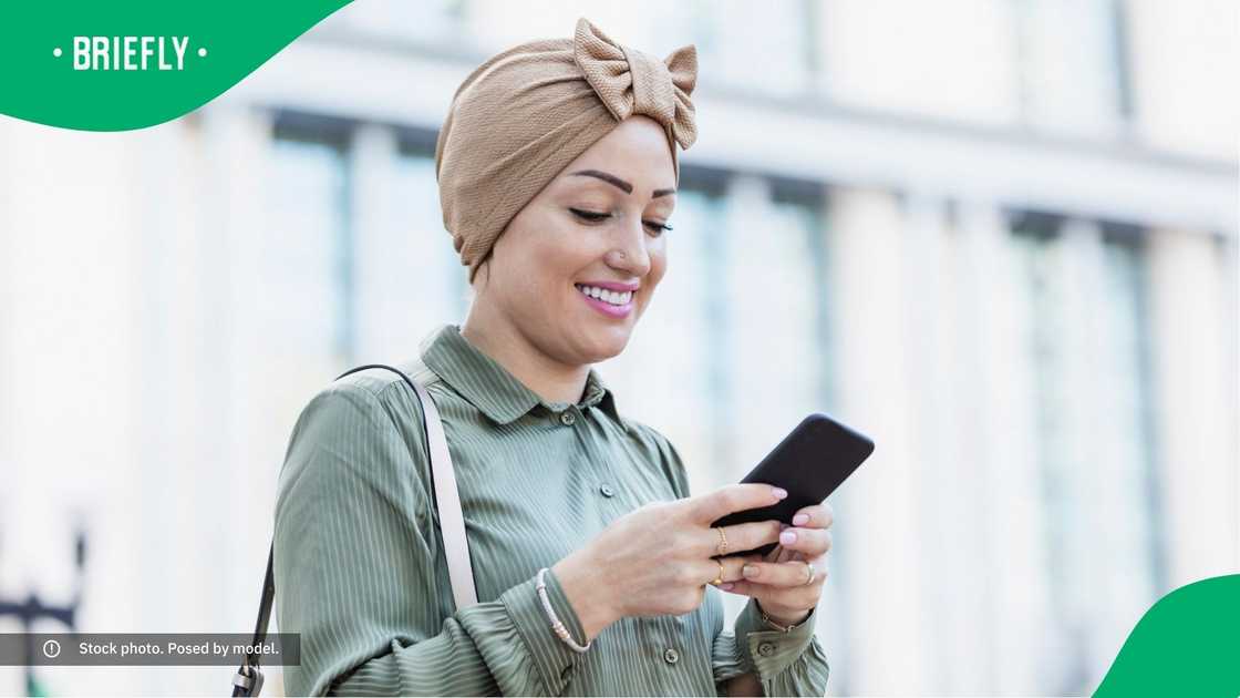 A woman smiling at her phone. A woman smiling at her phone.
