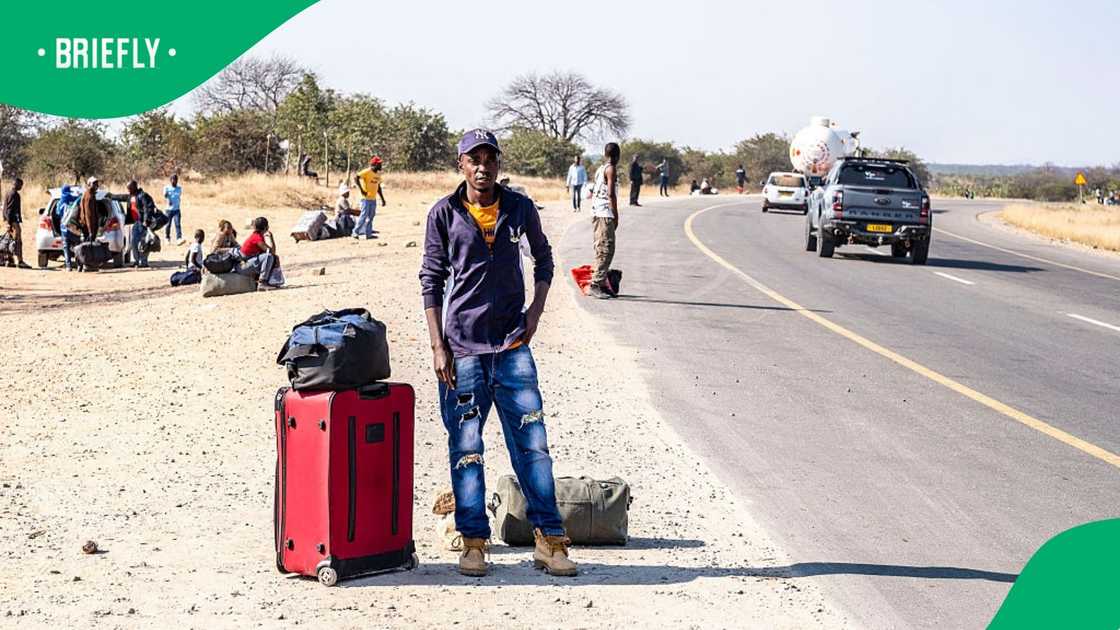 Tichaona Magomazi, 35, stands beside his luggage on the roadside outside Beitbridge town on July 10, 2026, after returning to Zimbabwe Tichaona Magomazi, 35, stands beside his luggage on the roadside outside Beitbridge town on July 10, 2026, after returning to Zimbabwe