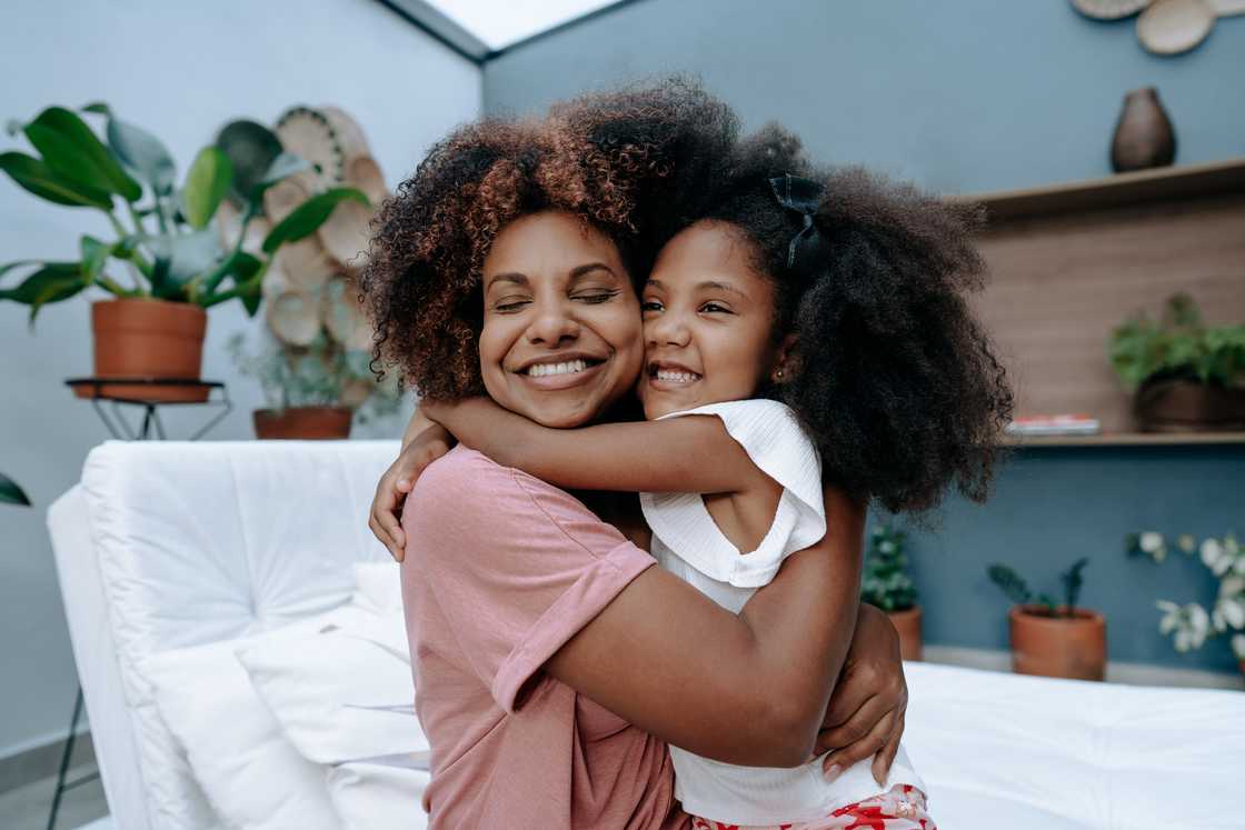 A mother and daughter embracing each other. A mother and daughter embracing each other.