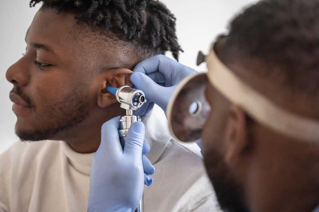 A physician examining the inside of an ear A physician examining the inside of an ear