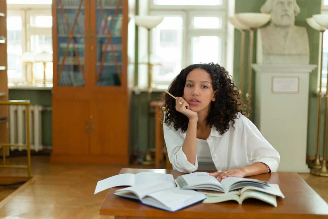 A young female student in a white top doing her revision