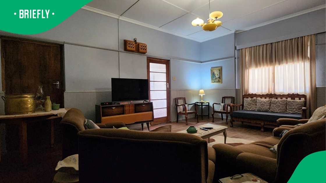 A cosy lounge area had been set up with classic decor, featuring a television, patterned seating, and curtains that filtered in natural light