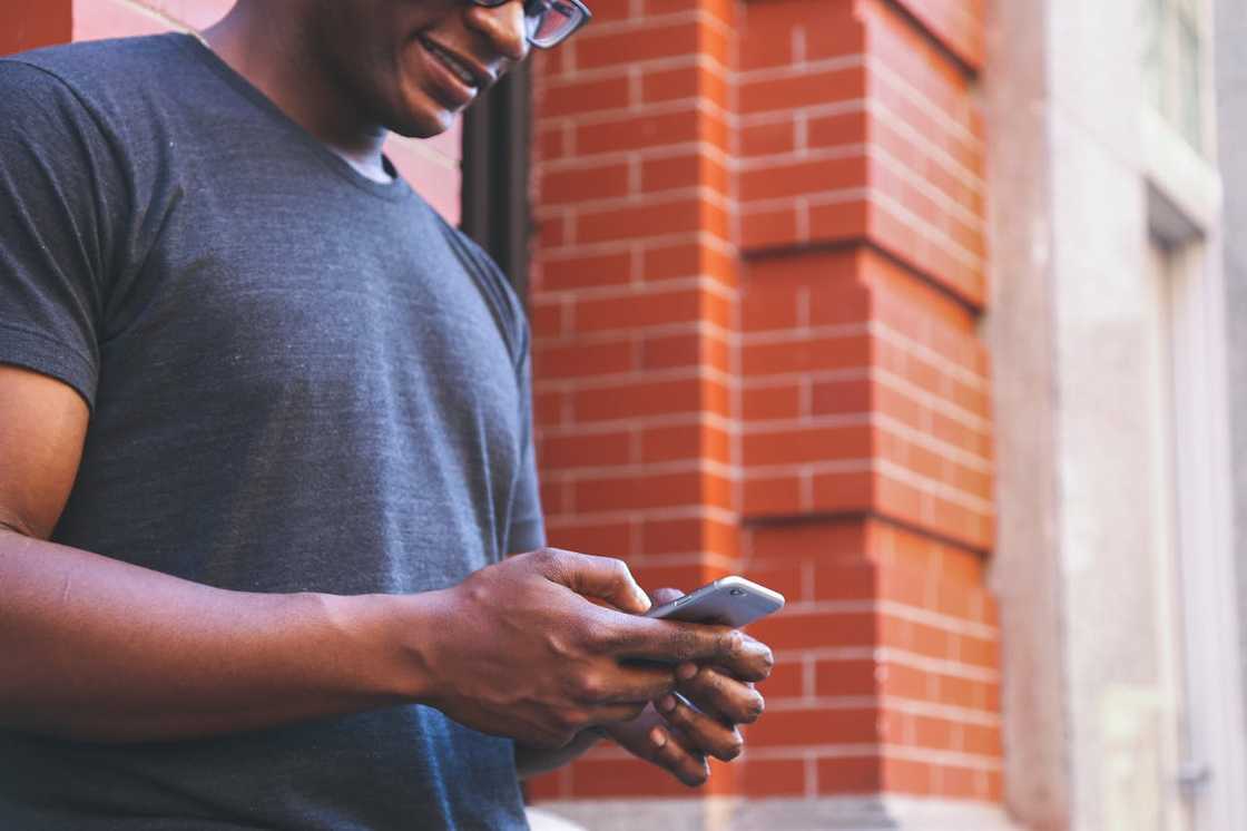 Close-up of a person holding and using a smartphone outdoors. Close-up of a person holding and using a smartphone outdoors.