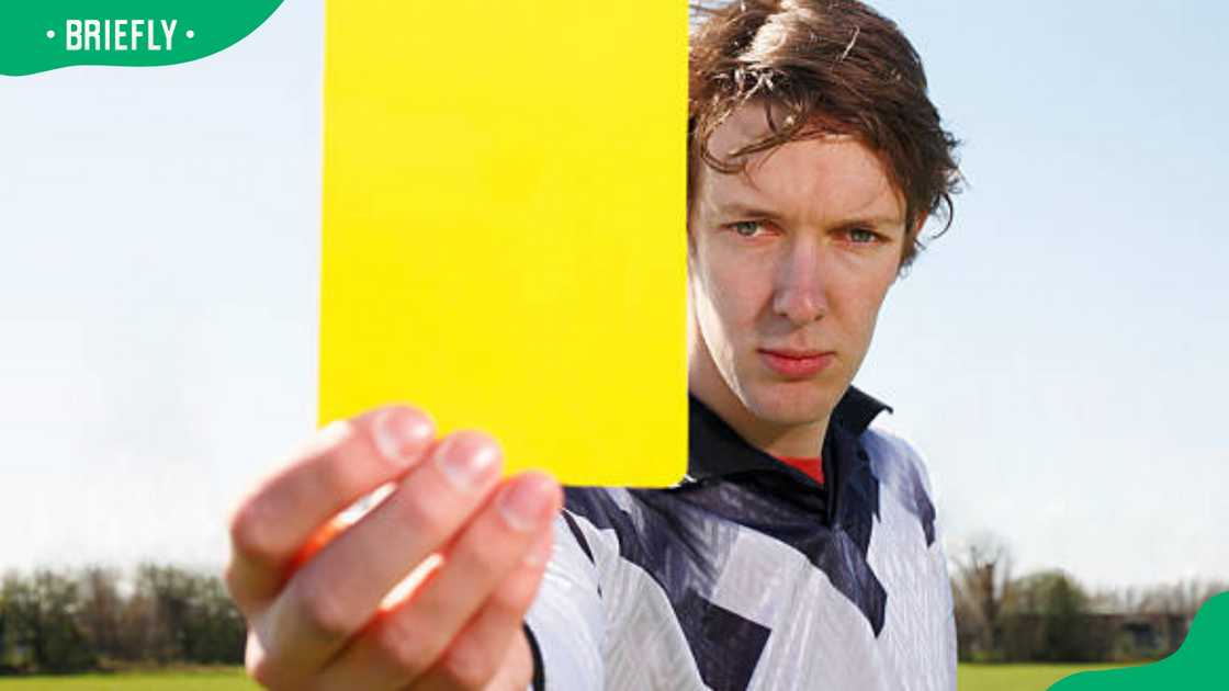 Soccer referee holding up yellow card