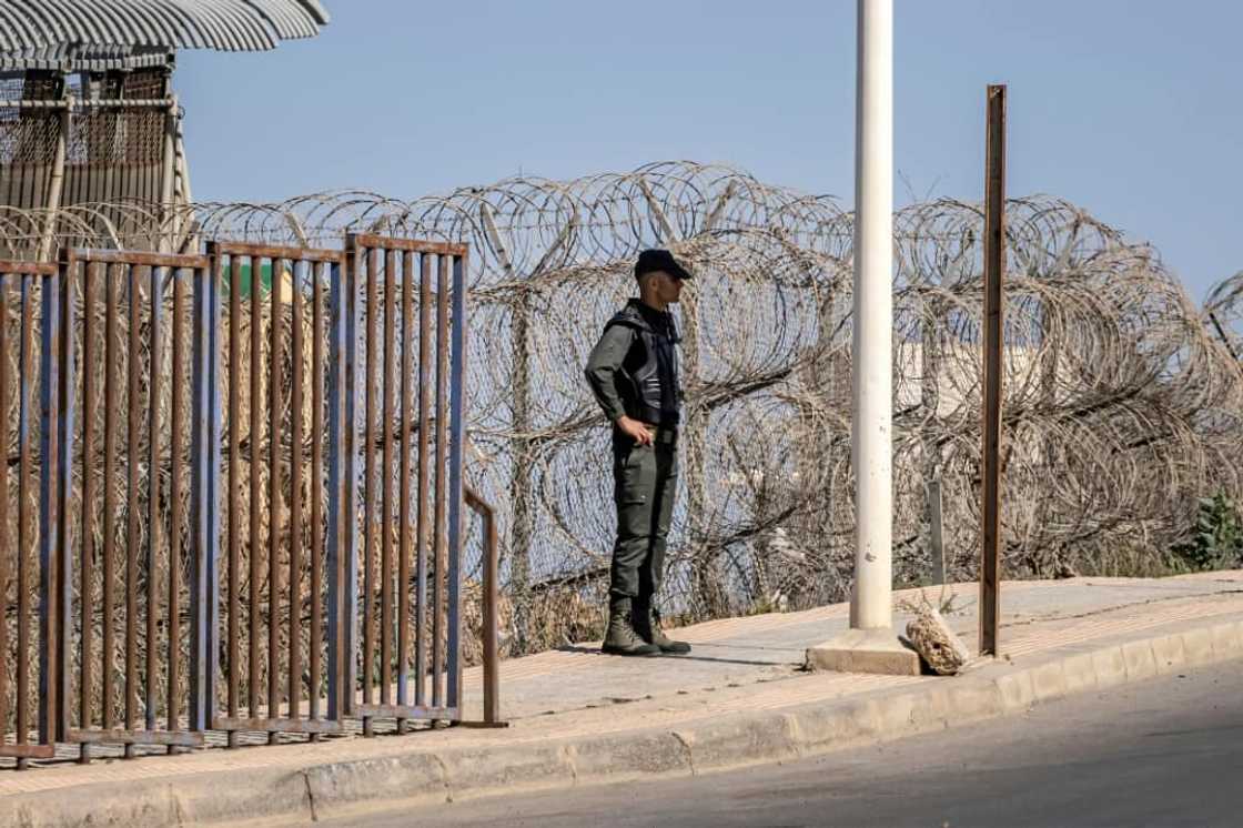 A Moroccan security officer stands guard on the border fence with Spain's North African Melilla enclave A Moroccan security officer stands guard on the border fence with Spain's North African Melilla enclave