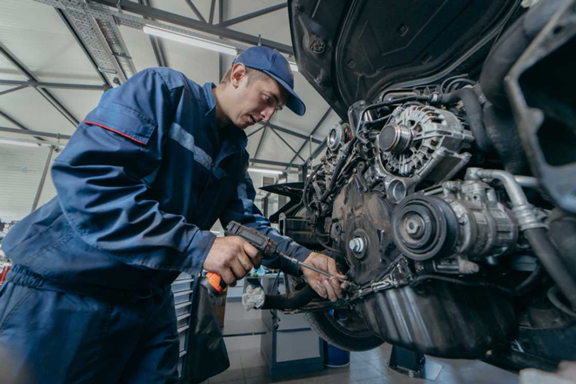 An auto mechanic repairing an engine