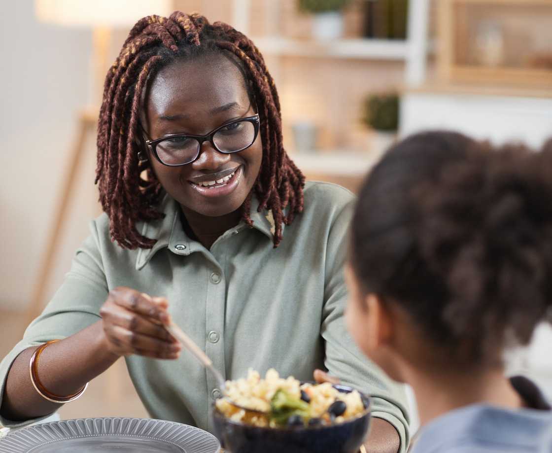 A mother sharing homemade meal with daughter