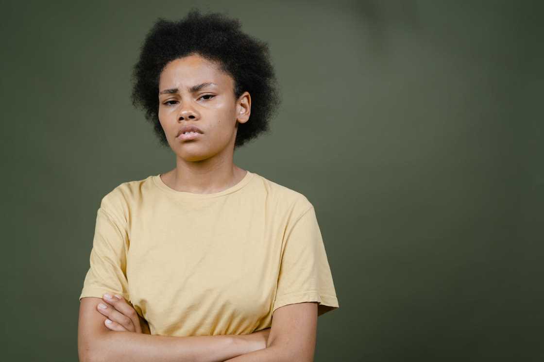 Young woman standing with arms crossed, looking serious. Young woman standing with arms crossed, looking serious.