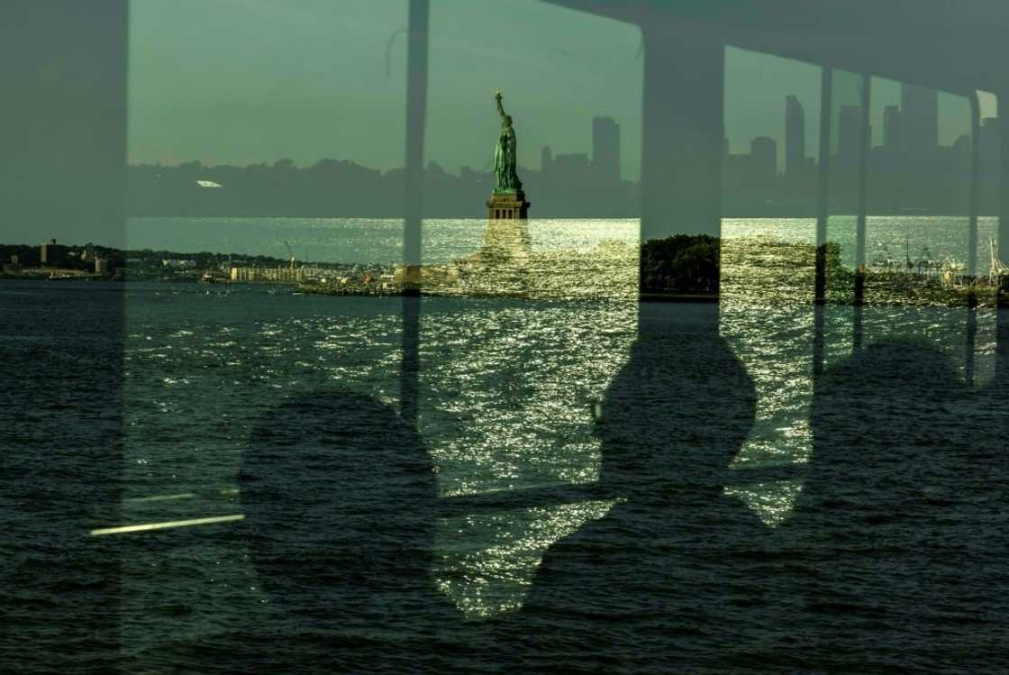 People riding the ferry to Ellis Island for a naturalization ceremony pass the Statue of Liberty People riding the ferry to Ellis Island for a naturalization ceremony pass the Statue of Liberty