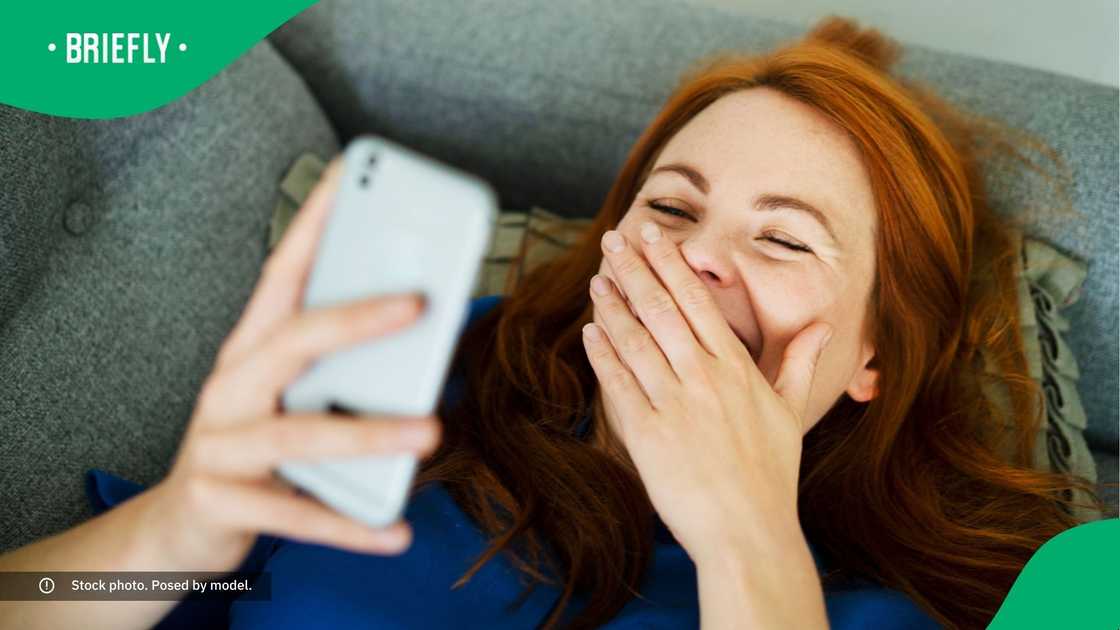 A woman laughing at her phone. A woman laughing at her phone.