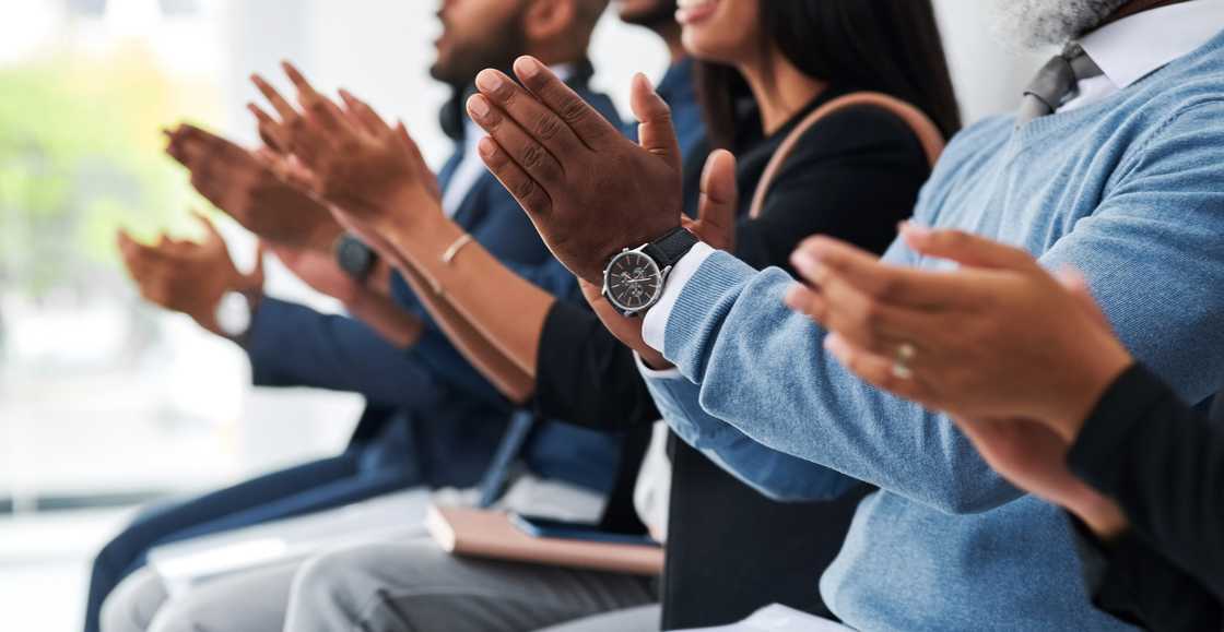 An audience applauding a woman on stage. An audience applauding a woman on stage.
