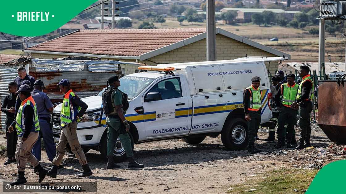 South African Police Service (SAPS) members and Gauteng Crime Prevention Wardens gather near the Forensic Pathology vehicle carrying the body of a person who died during a protest at Diepkloof Hostel in Soweto on May 19, 2025