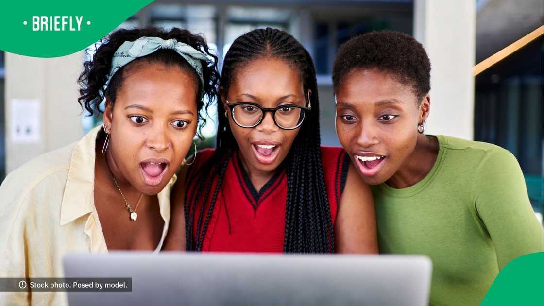 Three women looking at a computer screen. Three women looking at a computer screen.