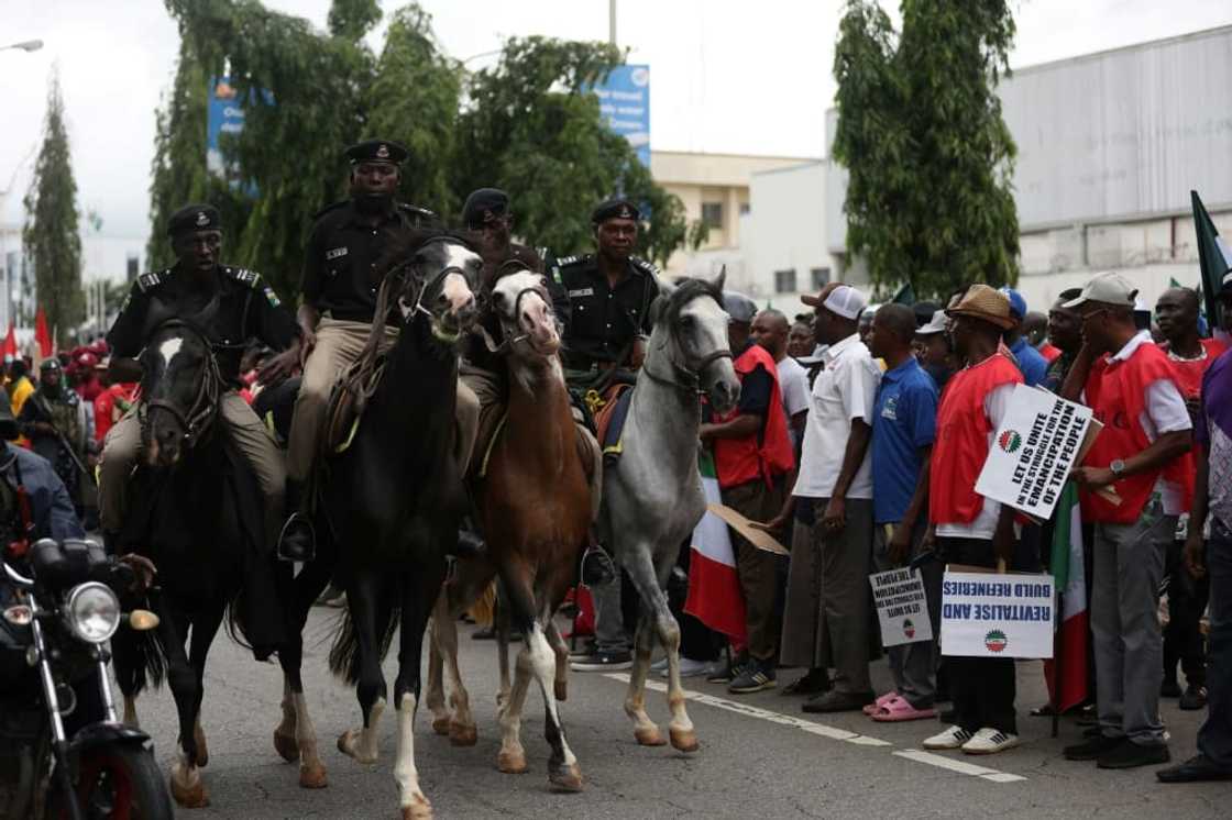 Mounted Nigerian police officers keep an eye on striking workers in Abuja Mounted Nigerian police officers keep an eye on striking workers in Abuja