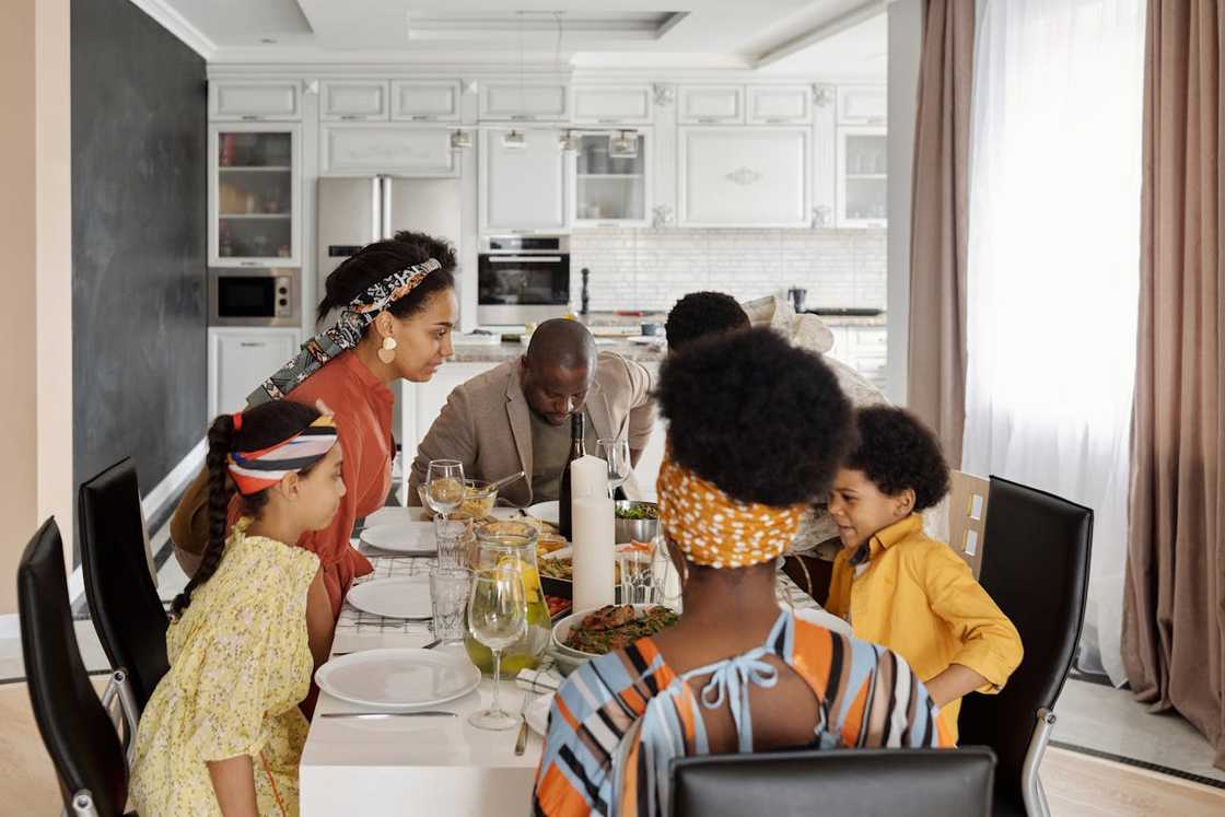 A family gathers around a dining table preparing to eat a meal. A family gathers around a dining table preparing to eat a meal.