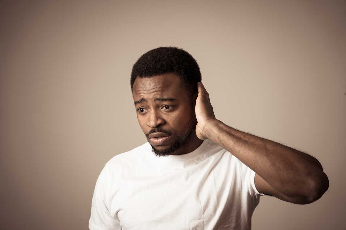 An ashamed man rubbing his head An ashamed man rubbing his head