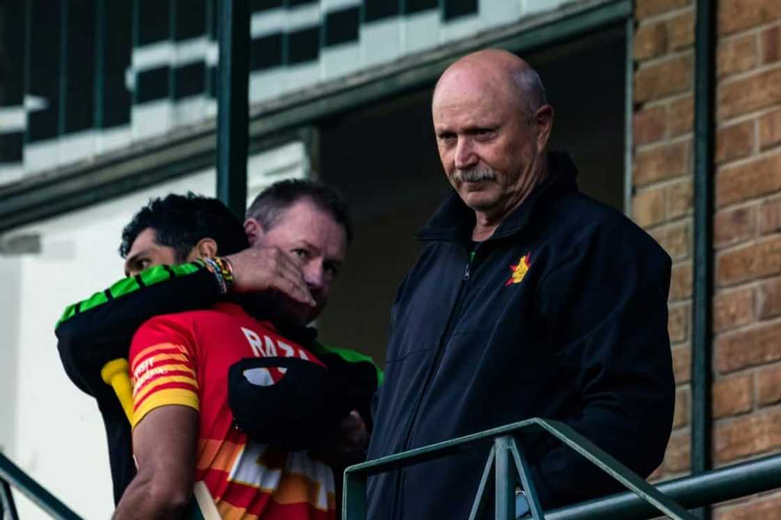 Hugs all round: Zimbabwe's influential coach David Houghton (R) looks on as batting coach Lance Klusener (L) congratulates Sikandar Raza after Sunday's win over Bangladesh