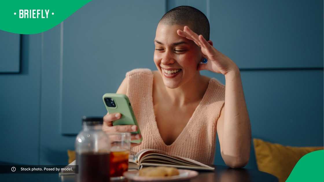 A woman smiling at her phone. A woman smiling at her phone.