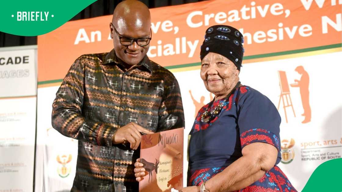 Ouma Katrina Esau received the N|uu Dictionary from Minister Nathi Mthethwa. Ouma Katrina Esau received the N|uu Dictionary from Minister Nathi Mthethwa.