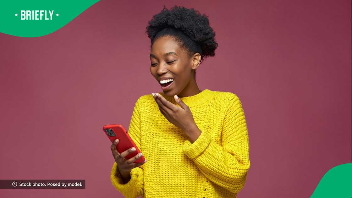 A woman laughing at her phone. A woman laughing at her phone.